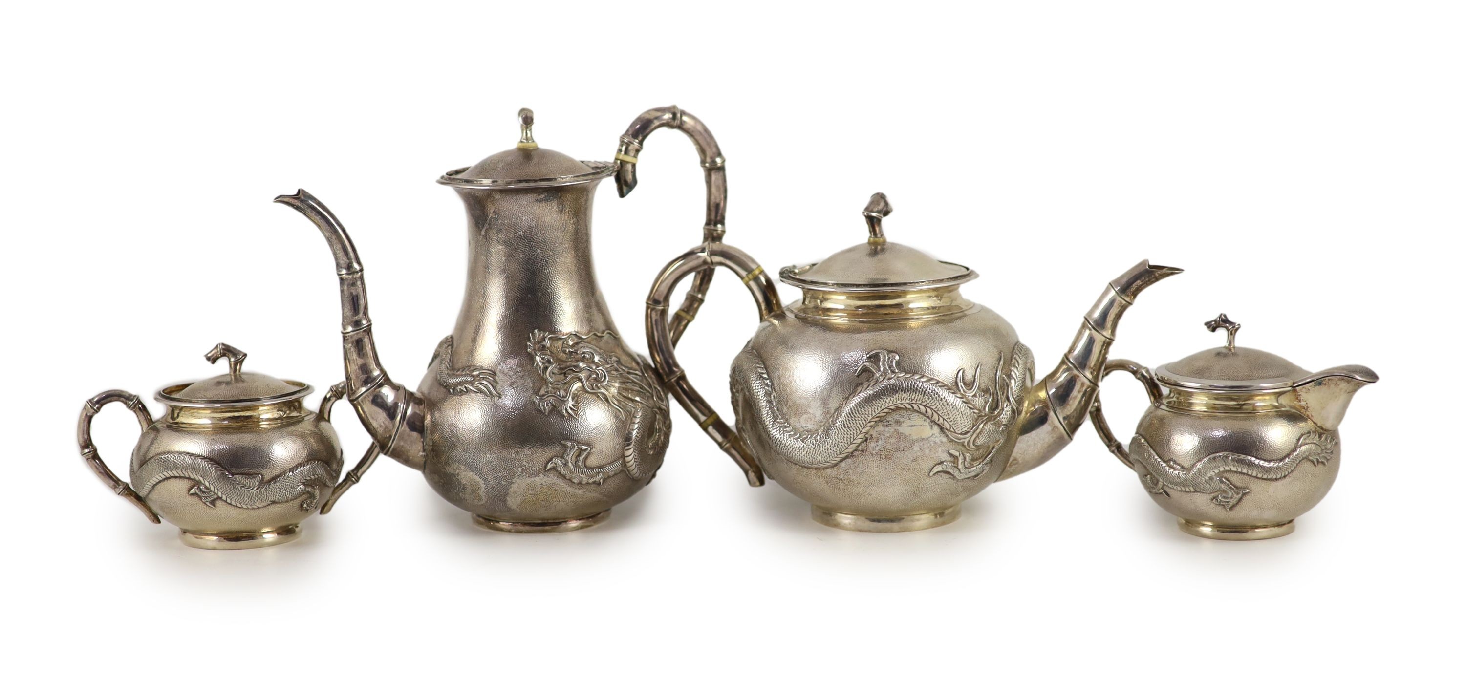 A matched early 20th century Chinese four piece planished silver tea and coffee set, cream and sugar by Wang Hing, teapot by Tack Hing and coffee pot apparently unmarked